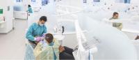 Faculty member conducts a dental procedure on a patient with a student.